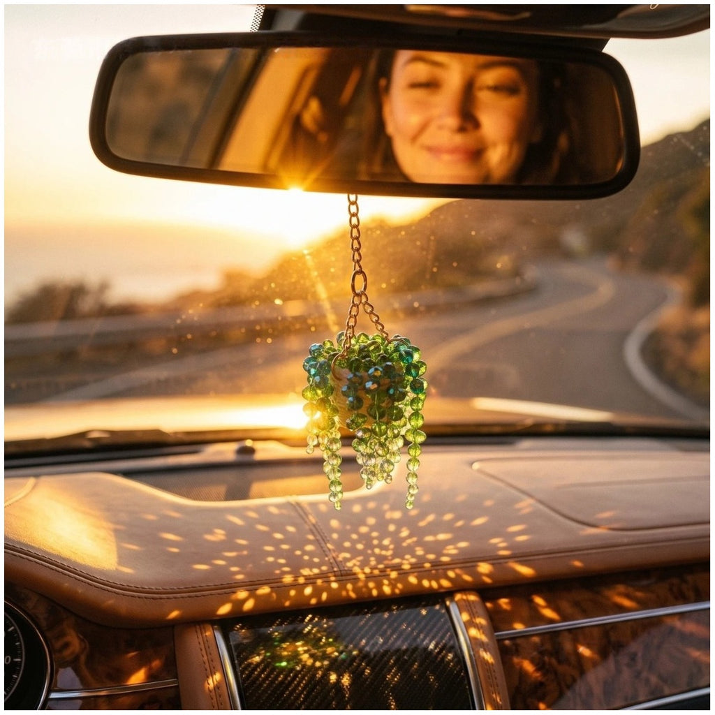 Succulent bead charm hanging from a car rearview mirror in sunlight